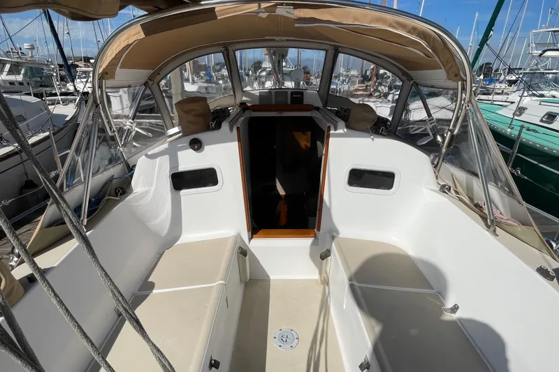 Slide: The Image of 2001 J Boats J/32 sailboat cockpit with beige canopy and seating at marina. - 9