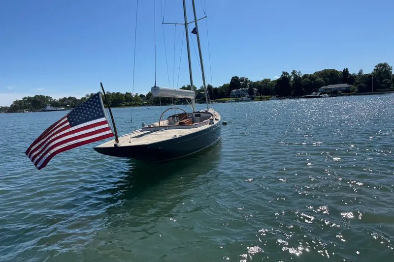 Slide: The Image of 2018 Leonardo Yachts Eagle 44 sailboat with American flag on calm water. - 2