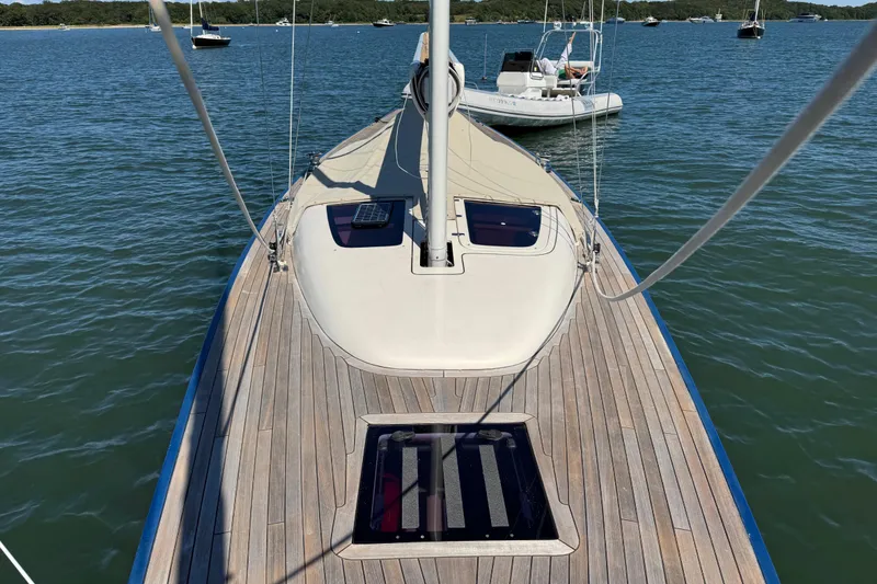 Slide: The Image of 2018 Leonardo Yachts Eagle 44 sailboat on calm water, showcasing sleek wooden deck design. - 8