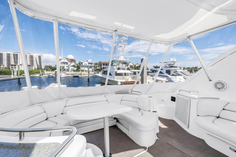 Slide: The Image of Luxurious 2002 Cruisers 5370 yacht interior with white seating, marina view, and clear skies. - 10