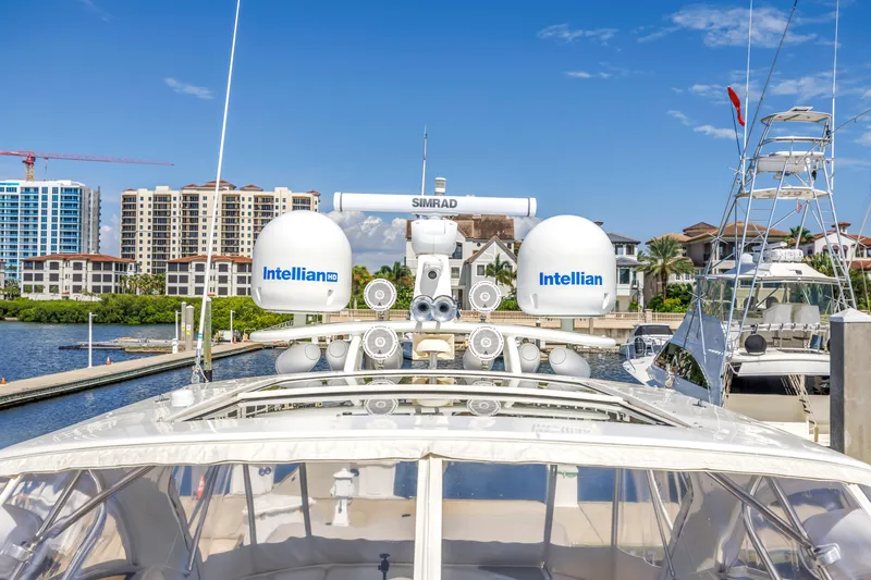 Slide: The Image of Luxury 2002 Cruisers 5370 yacht docked, featuring Intellian satellite systems and Simrad equipment. - 20