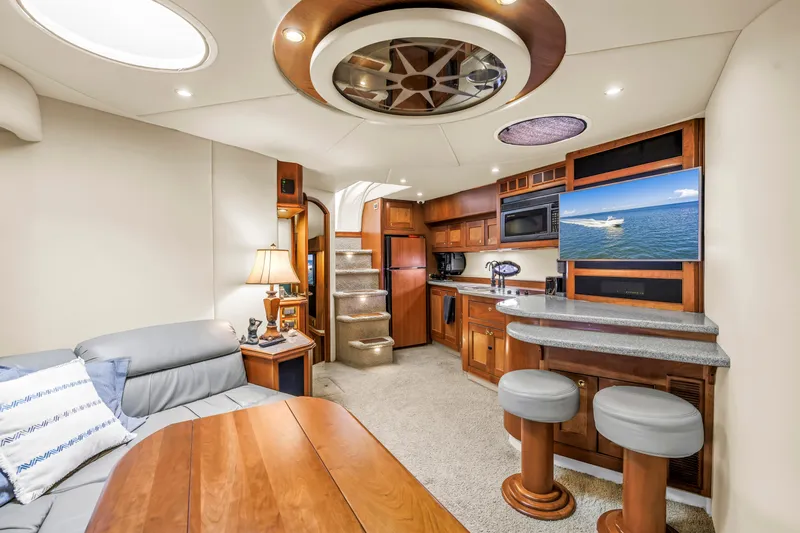 Slide: The Image of Luxurious 2002 Cruisers 5370 yacht interior with modern kitchen, seating, and entertainment area. - 22