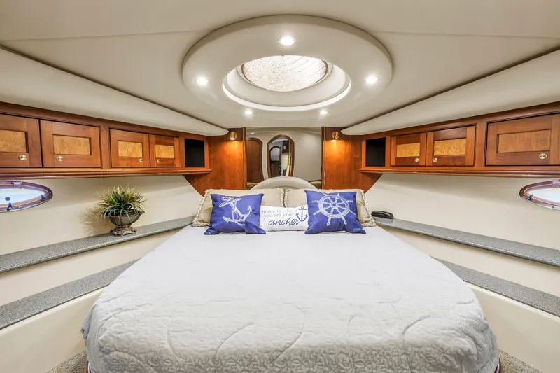 Slide: The Image of Luxurious 2002 Cruisers 5370 yacht bedroom with elegant wood cabinetry and nautical decor. - 27