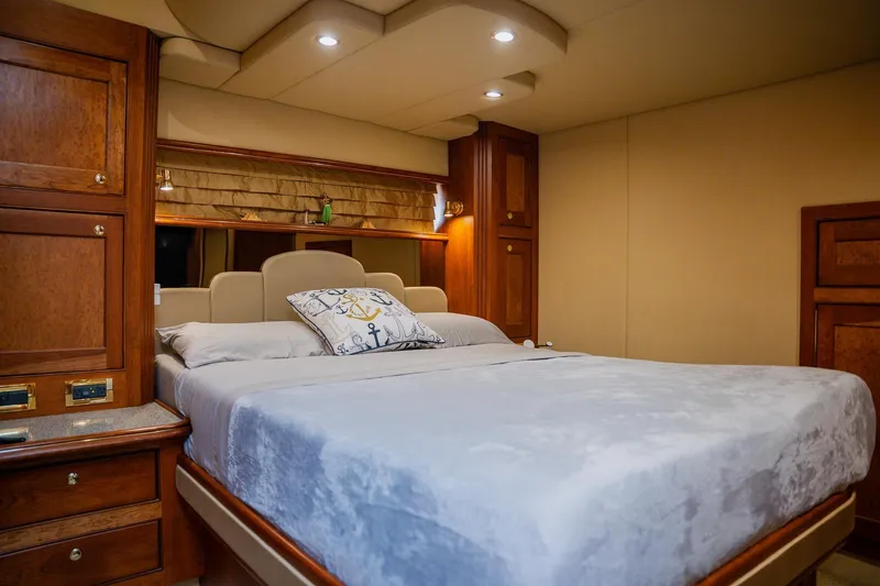 Slide: The Image of Luxurious 2002 Cruisers 5370 yacht bedroom with elegant wood cabinetry and plush bedding. - 29