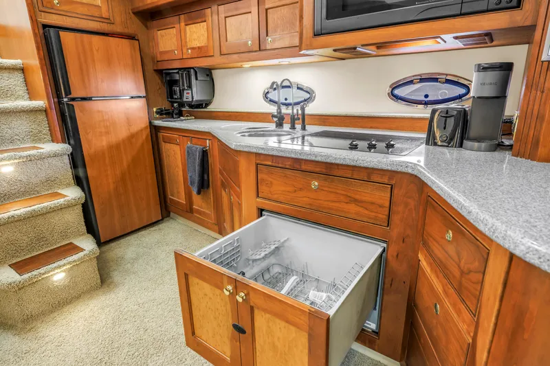 Slide: The Image of Luxurious 2002 Cruisers 5370 yacht kitchen with wood cabinetry, dishwasher, and modern appliances. - 32