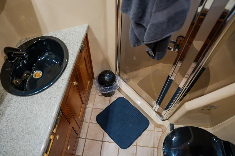 Slide: The Image of Bathroom interior of 2002 Cruisers 5370 yacht with sink, shower, and mat. - 33