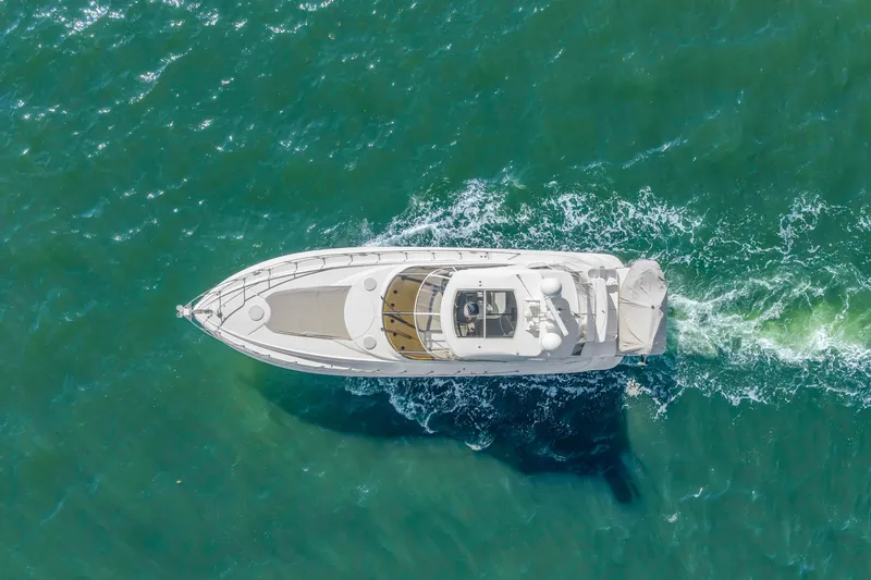 Slide: The Image of Aerial view of 2002 Cruisers 5370 yacht cruising on turquoise water. - 7