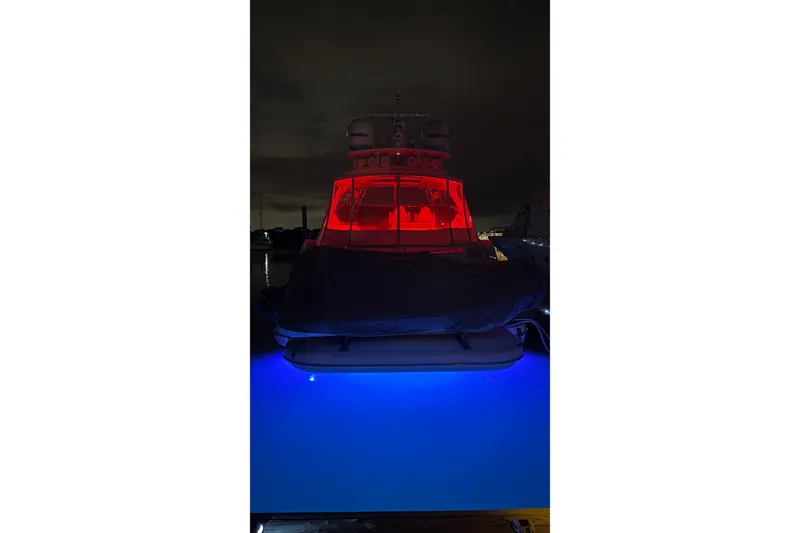 Slide: The Image of 2002 Cruisers 5370 yacht with red and blue lights at night. - 19