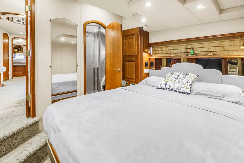 Slide: The Image of Luxurious 2002 Cruisers 5370 yacht bedroom with elegant wood accents and nautical-themed decor. - 25