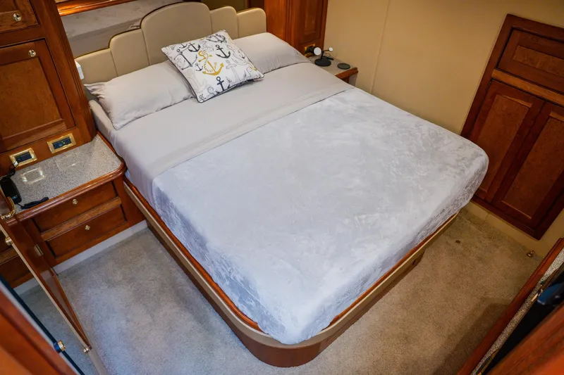 Slide: The Image of Luxurious 2002 Cruisers 5370 yacht bedroom with elegant bedding and wooden cabinetry. - 28