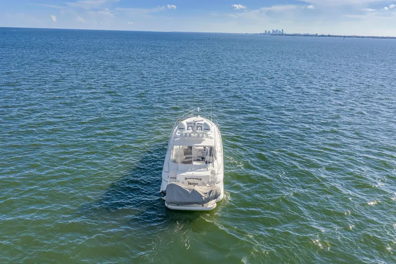 Slide: The Image of 2002 Cruisers 5370 yacht on open water with distant city skyline. - 4