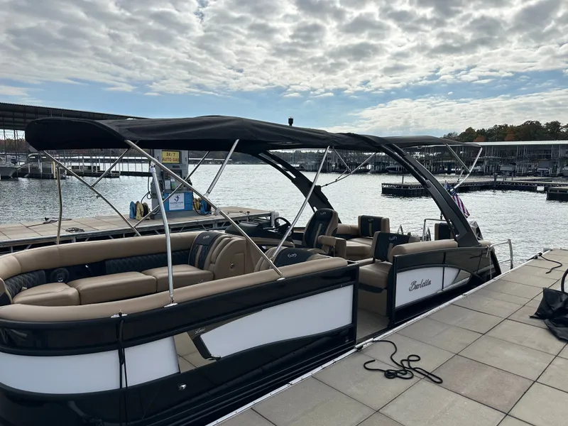 Slide: The Image of 2026 Barletta L25MA pontoon boat docked under cloudy sky. - 44