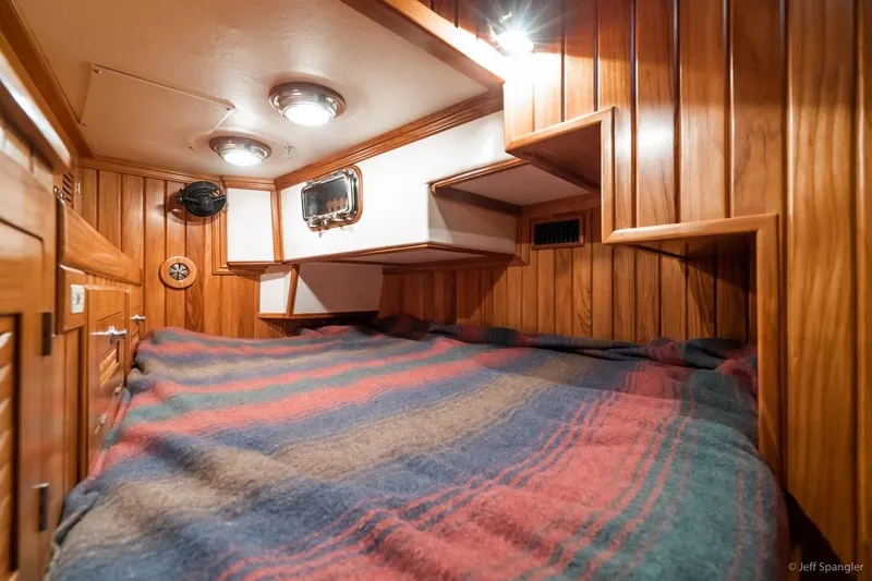 Slide: The Image of Cozy cabin interior of 2005 Cabo Rico 42 Pilot with wood paneling and striped bedding. - 11