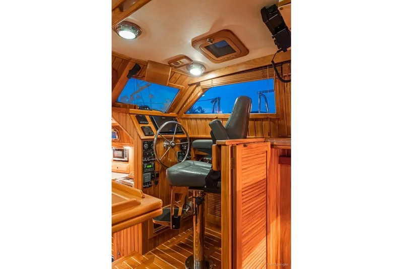 Slide: The Image of Luxurious 2005 Cabo Rico 42 Pilot yacht interior with wooden helm and captain's chair. - 14