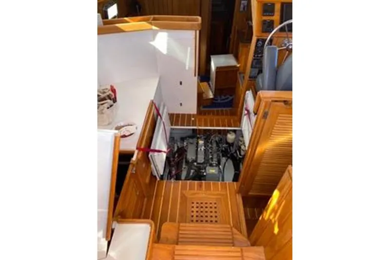 Slide: The Image of 2005 Cabo Rico 42 Pilot interior with open engine compartment, showcasing wooden flooring and cabinetry. - 30