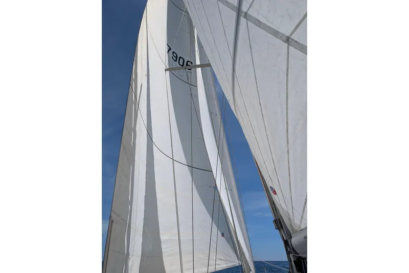 Slide: The Image of Sails of a 2004 Cabo Rico 42 yacht against a clear blue sky. - 36