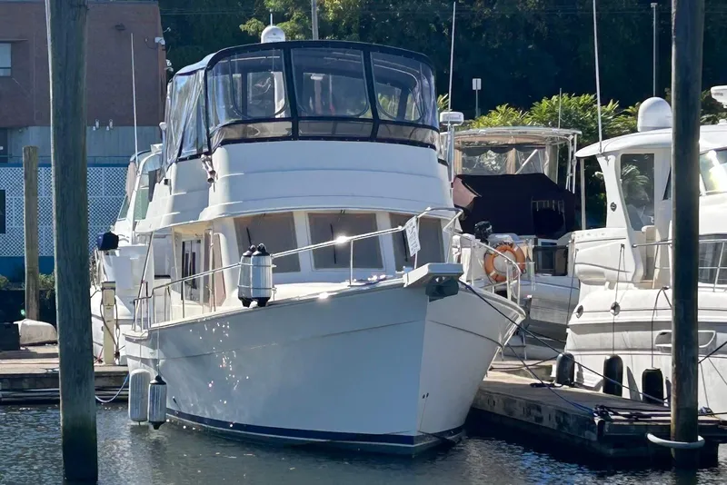 Slide: The Image of 2007 Mainship 34 Trawler docked at marina, featuring sleek design and spacious upper deck. - 2