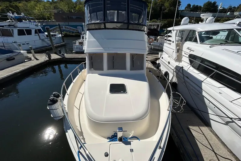Slide: The Image of 2007 Mainship 34 Trawler docked at marina, surrounded by other boats. - 3