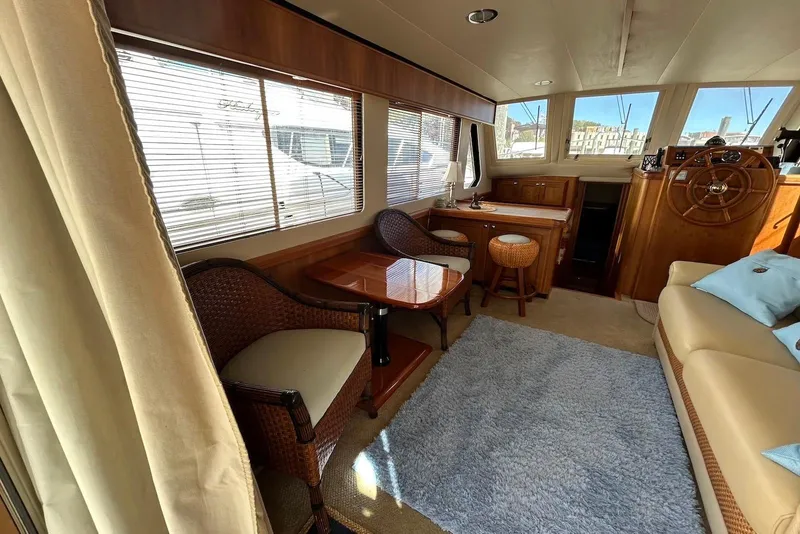 Slide: The Image of Interior of 2007 Mainship 34 Trawler with elegant seating and wooden helm. - 6