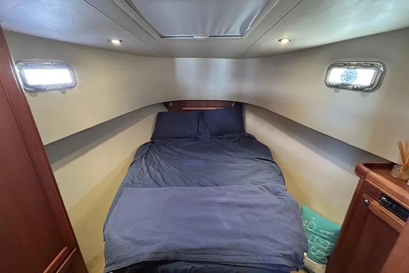 Slide: The Image of Cozy cabin interior of 2007 Mainship 34 Trawler with bed and porthole windows. - 8