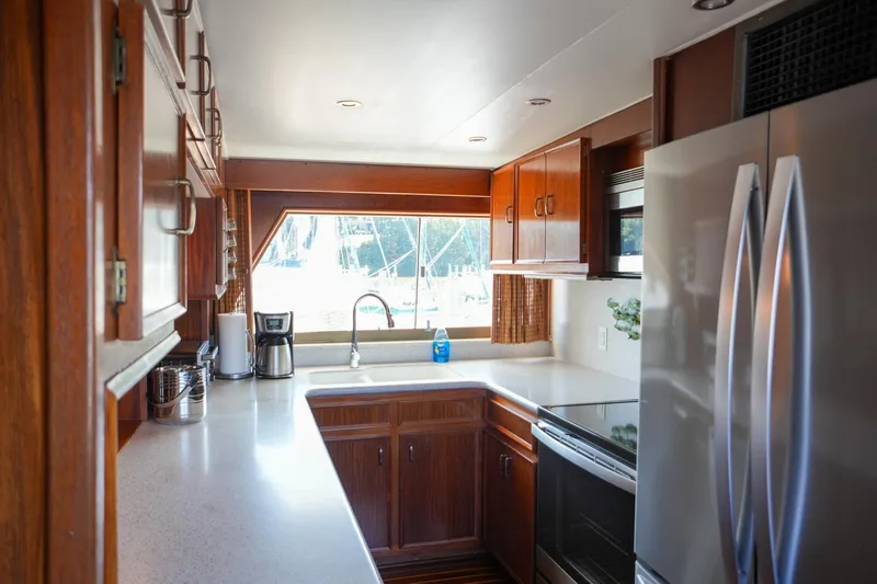 Slide: The Image of Luxurious 1980 Hatteras 70 Motor Yacht interior with ocean view, wicker chairs, and wooden table. - 13