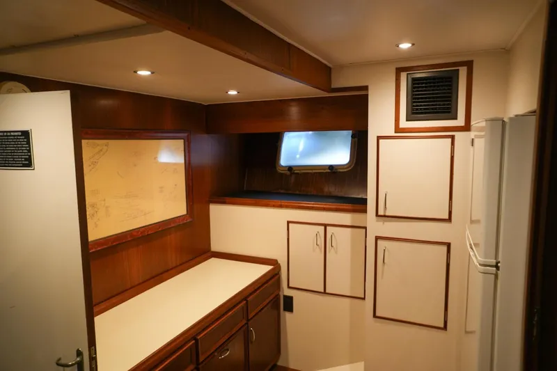 Slide: The Image of Luxurious 1980 Hatteras 70 Motor Yacht bedroom with elegant wood paneling and cozy bedding. - 21