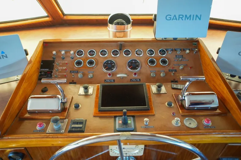 Slide: The Image of 1980 Hatteras 70 Motor Yacht cruising on open water with American flag. - 3