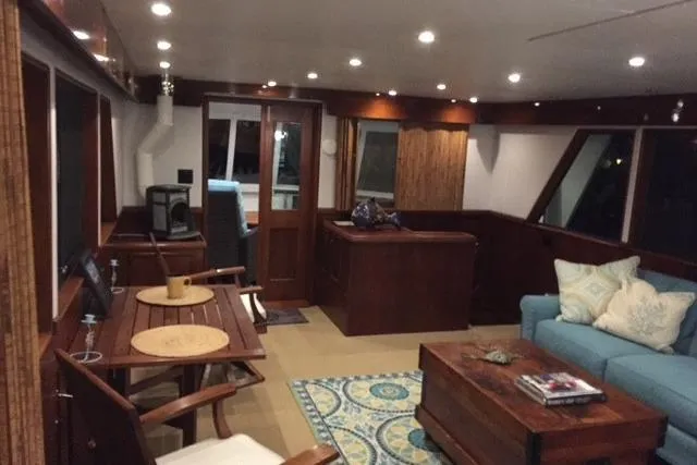 Slide: The Image of 1980 Hatteras 70 Motor Yacht cruising on calm waters under clear blue sky. - 5