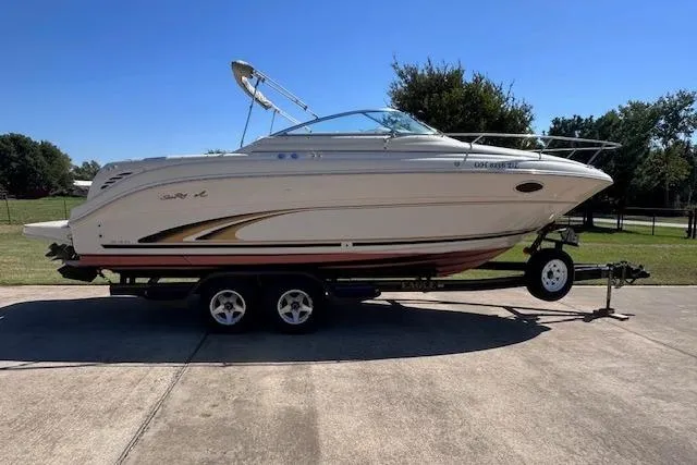 The Image of 2001 Sea Ray 245 Weekender boat on trailer, parked outdoors. - 0