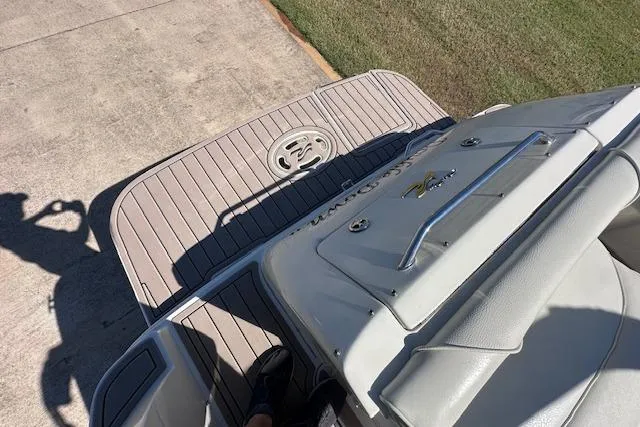 Slide: The Image of 2001 Sea Ray 245 Weekender boat deck with seating and shadow on pavement. - 11