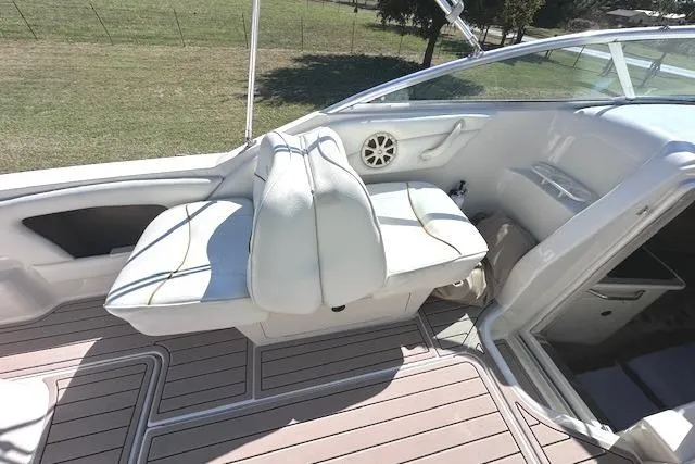 Slide: The Image of 2001 Sea Ray 245 Weekender boat interior with white seating and wood flooring. - 13