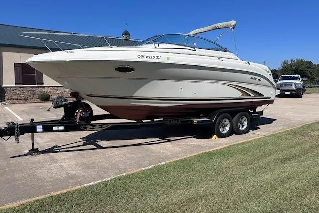 Slide: The Image of 2001 Sea Ray 245 Weekender boat on trailer, parked outdoors on sunny day. - 2