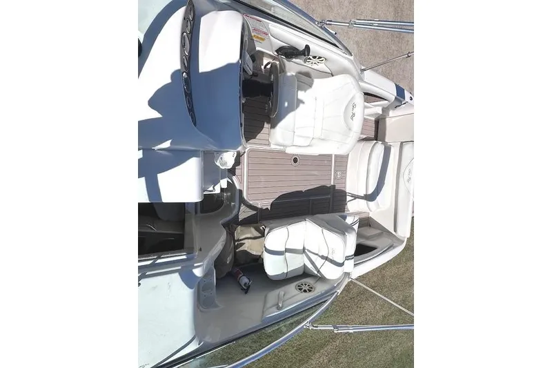 Slide: The Image of 2001 Sea Ray 245 Weekender boat interior with white seating and steering console. - 20