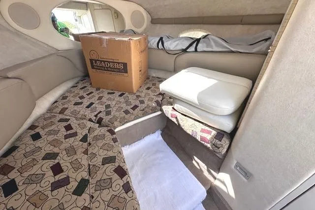Slide: The Image of 2001 Sea Ray 245 Weekender cabin interior with patterned cushions and a cardboard box. - 22
