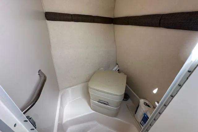 Slide: The Image of 2001 Sea Ray 245 Weekender boat interior with compact toilet and storage space. - 29
