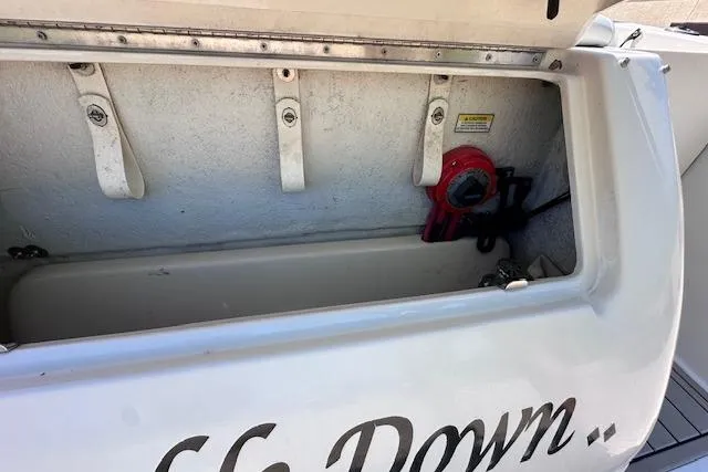 Slide: The Image of Storage compartment of a 2001 Sea Ray 245 Weekender boat, featuring safety equipment. - 35