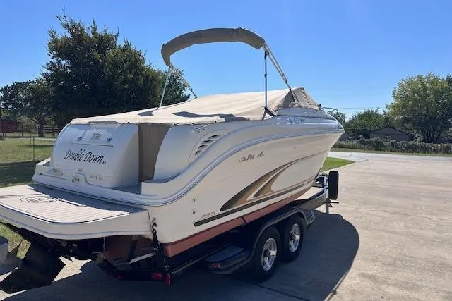 Slide: The Image of 2001 Sea Ray 245 Weekender boat on trailer, parked outdoors under clear sky. - 37