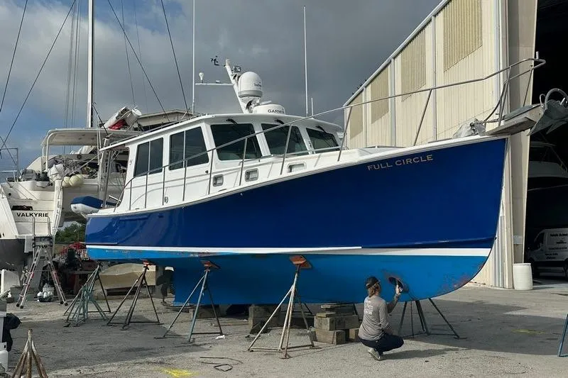 Slide: The Image of 2006 Duffy 37 Downeast boat in dry dock, blue hull, maintenance underway. - 13