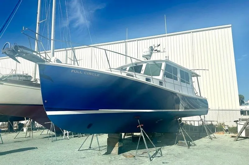 Slide: The Image of 2006 Duffy 37 Downeast boat named "Full Circle" on dry dock under clear blue sky. - 14