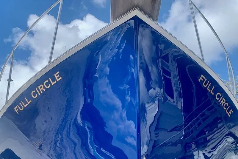 Slide: The Image of 2006 Duffy 37 Downeast boat named "Full Circle" with reflective blue hull under cloudy sky. - 15