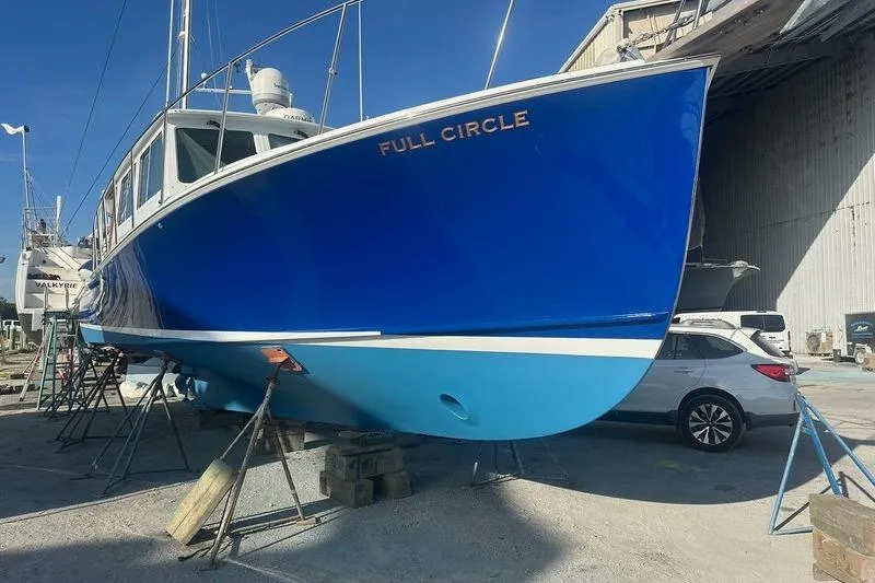 Slide: The Image of 2006 Duffy 37 Downeast boat named "Full Circle" in dry dock, vibrant blue hull. - 19