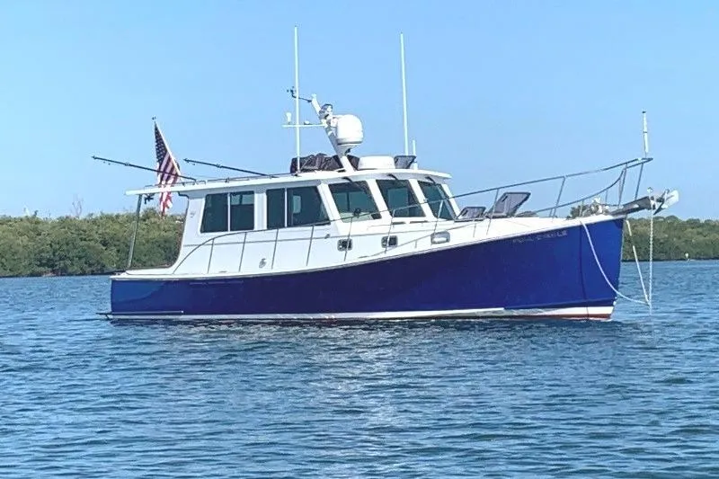 Slide: The Image of 2006 Duffy 37 Downeast boat on calm water with American flag. - 3