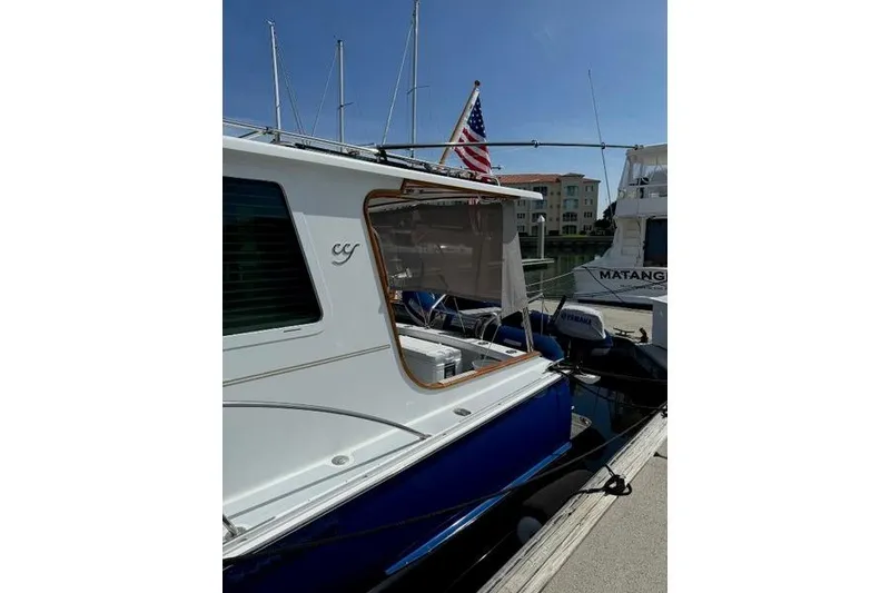 Slide: The Image of 2006 Duffy 37 Downeast boat docked, featuring American flag and marina backdrop. - 36