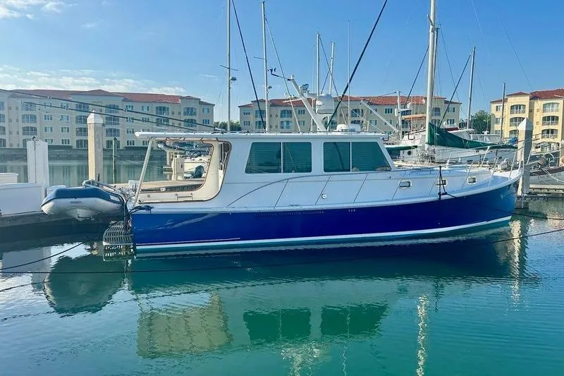 Slide: The Image of 2006 Duffy 37 Downeast boat docked in marina, reflecting on calm water. - 5
