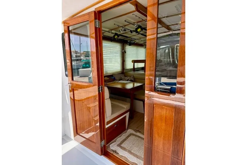 Slide: The Image of 2006 Duffy 37 Downeast boat interior with wooden doors and cozy seating area. - 52