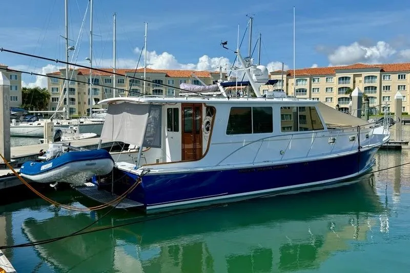 Slide: The Image of 2006 Duffy 37 Downeast boat docked in marina with inflatable dinghy attached. - 8