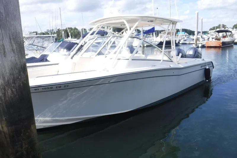 The Image of 2020 Grady-White Freedom 285 boat docked in a marina, surrounded by other vessels. - 0