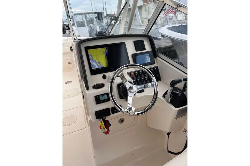 Slide: The Image of 2020 Grady-White Freedom 285 boat dashboard with navigation system and steering wheel. - 3