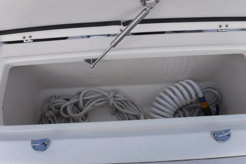Slide: The Image of Storage compartment on a 2020 Grady-White Freedom 285 boat with coiled ropes and hose. - 30