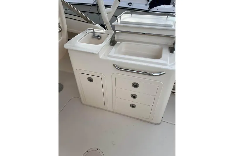 Slide: The Image of 2020 Grady-White Freedom 285 boat interior with sink and storage compartments. - 5